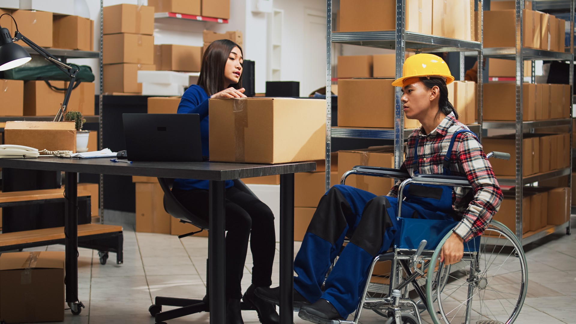 Male worker with impairment taking boxes off of shelves